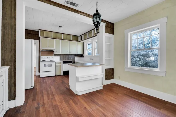 a kitchen with wooden floors and white cabinets