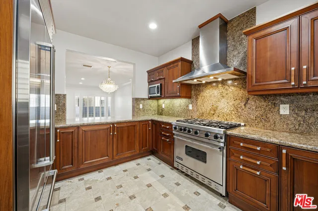 a kitchen with stainless steel appliances granite countertop a stove a sink and a refrigerator