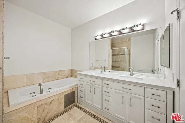 a spacious bathroom with double sink a large mirror and a shower