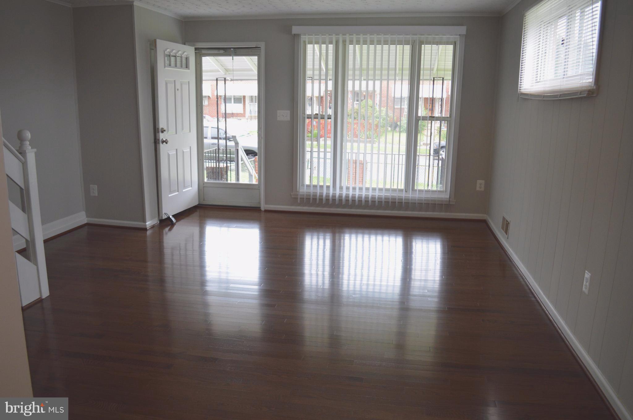 8223 Kavanagh Road Baltimore, MD 21222 - Photo 6 of 17 a view of an empty room with wooden floor and a window