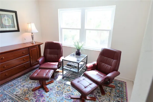 a living room with furniture a rug and a window