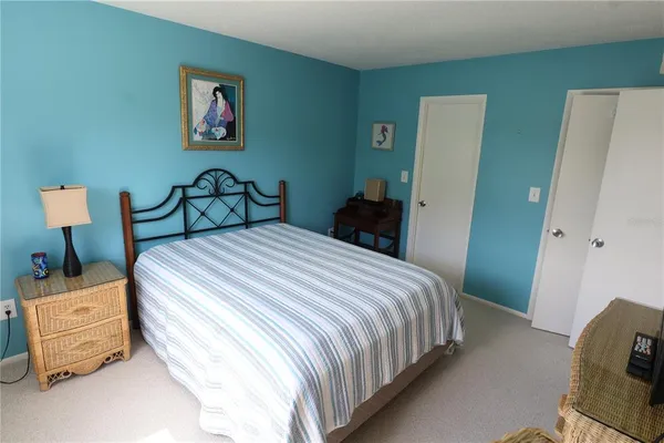 a bedroom with a bed and a painting on the wall