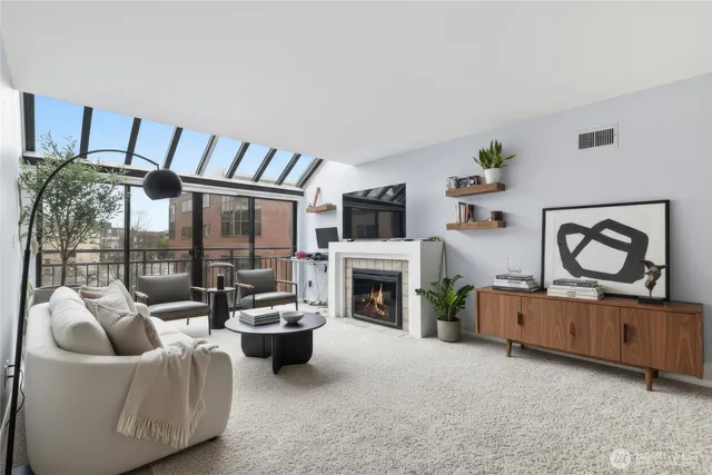 a living room with furniture a fireplace and a flat screen tv
