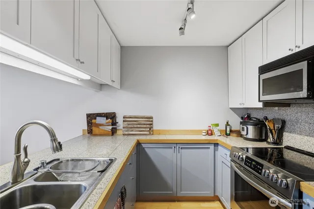 a kitchen with stainless steel appliances a stove a sink a stove and cabinets