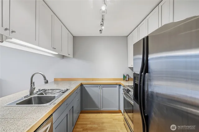 a kitchen with stainless steel appliances a sink and a refrigerator