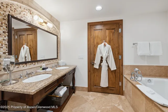 a bathroom with a tub sink and mirror
