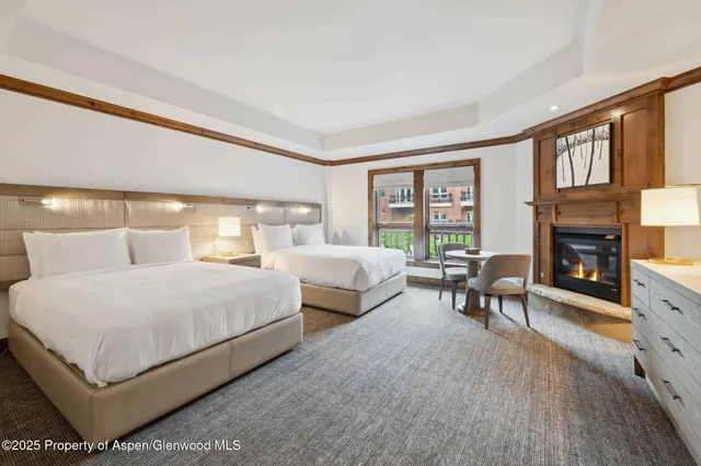 a bedroom with two beds and a fireplace