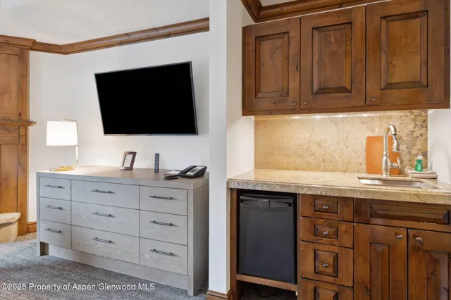 a living room with flat screen tv and cabinets