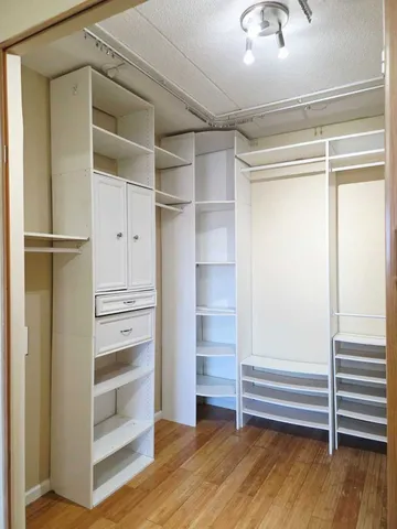 a view of walk in closet with empty racks