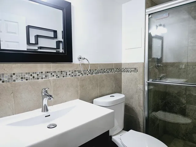 a bathroom with a toilet a sink and mirror