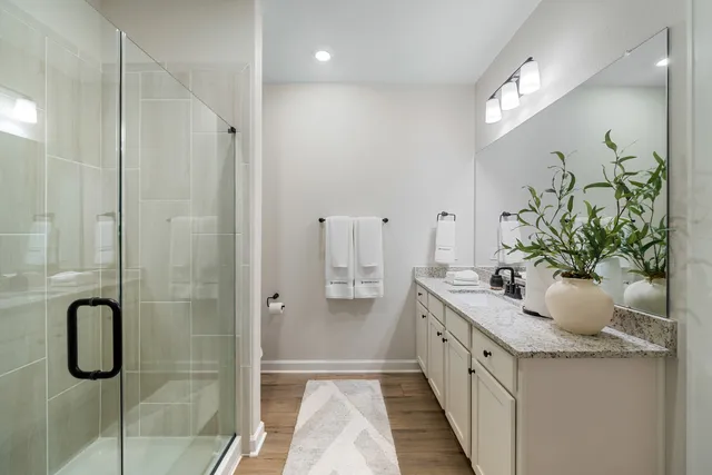 a bathroom with a granite countertop sink a shower and a mirror