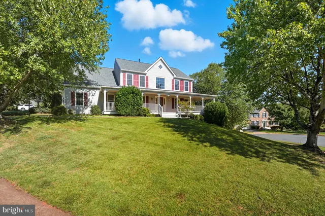 a view of a house next to a big yard and large trees
