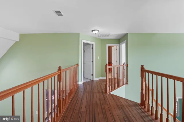 a view of staircase with railing and wooden floor
