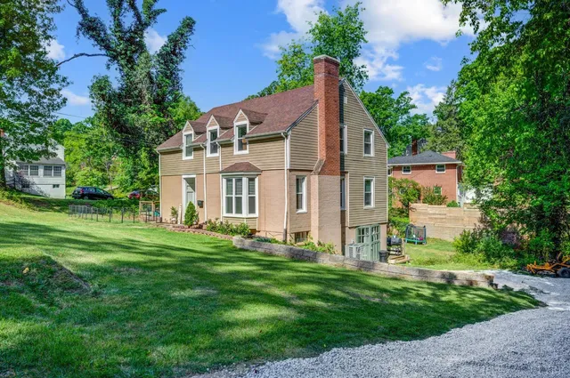 a aerial view of a house next to a big yard and large trees