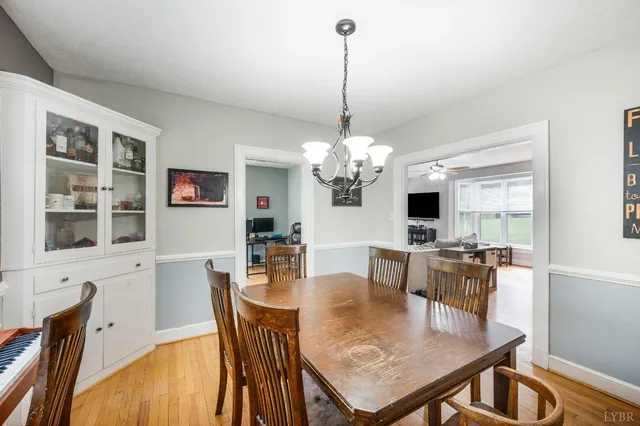 a view of a dining room with furniture a chandelier and wooden floor