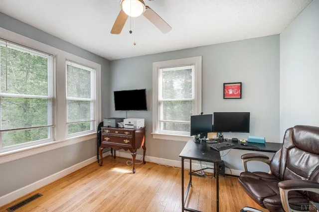 a view of a workspace with furniture and a window