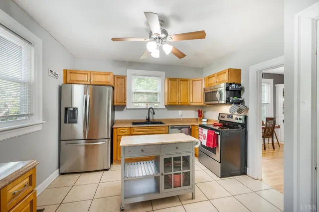 a kitchen with stainless steel appliances granite countertop a refrigerator stove top oven and sink