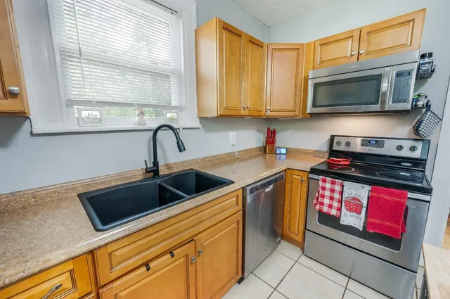 a kitchen with stainless steel appliances granite countertop a stove a sink and a microwave