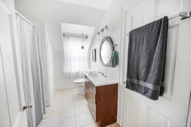 a bathroom with a sink vanity mirror and toilet