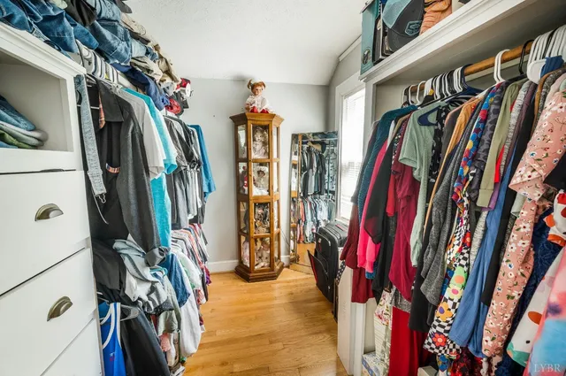 a view of walk in closet with clothes