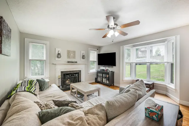 a living room with furniture a fireplace and a flat screen tv