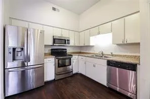 a kitchen with granite countertop a refrigerator stove and sink