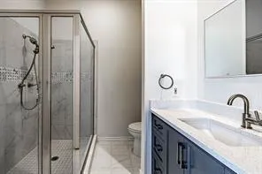 a bathroom with a granite countertop sink a toilet and shower