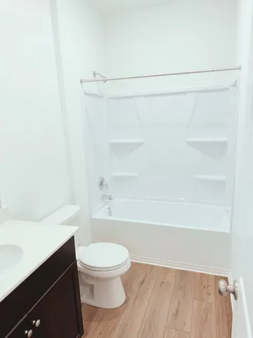 a white toilet sitting next to a white wall