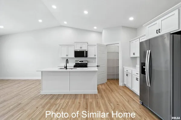 a kitchen with stainless steel appliances a refrigerator sink and microwave