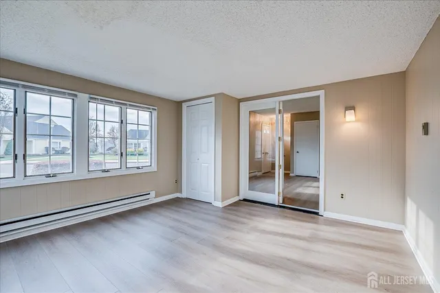 an empty room with wooden floor and windows