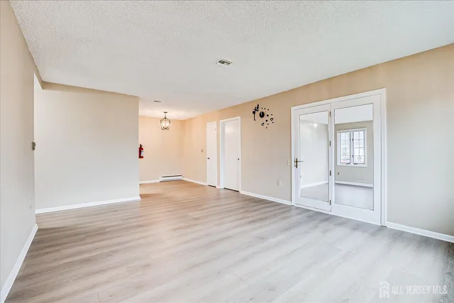 a view of an empty room with wooden floor