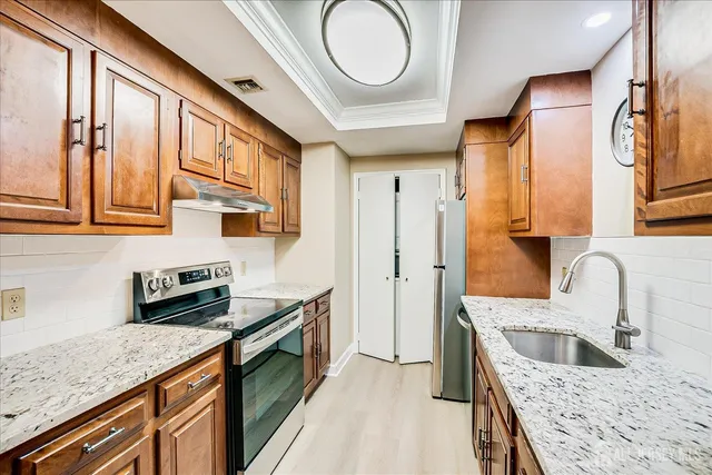 a kitchen with stainless steel appliances granite countertop a sink and a stove