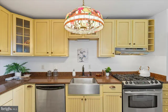 a kitchen with stainless steel appliances granite countertop a sink and a stove