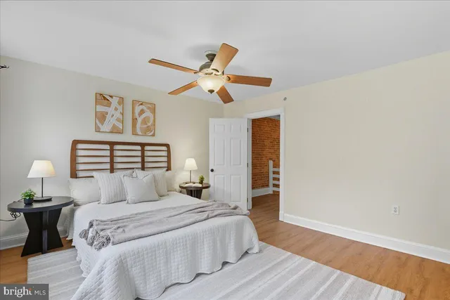 a bedroom with a large bed and a ceiling fan