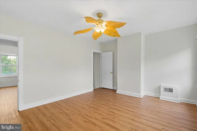 a view of empty room with wooden floor