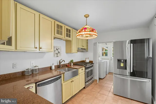 a kitchen with stainless steel appliances granite countertop a sink a stove and refrigerator