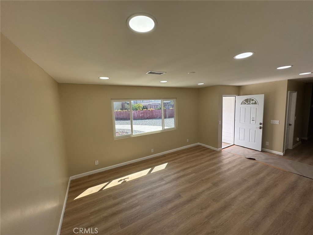 5276 Almar Street Riverside, CA 92505 - Photo 5 of 13 an empty room with wooden floor and windows