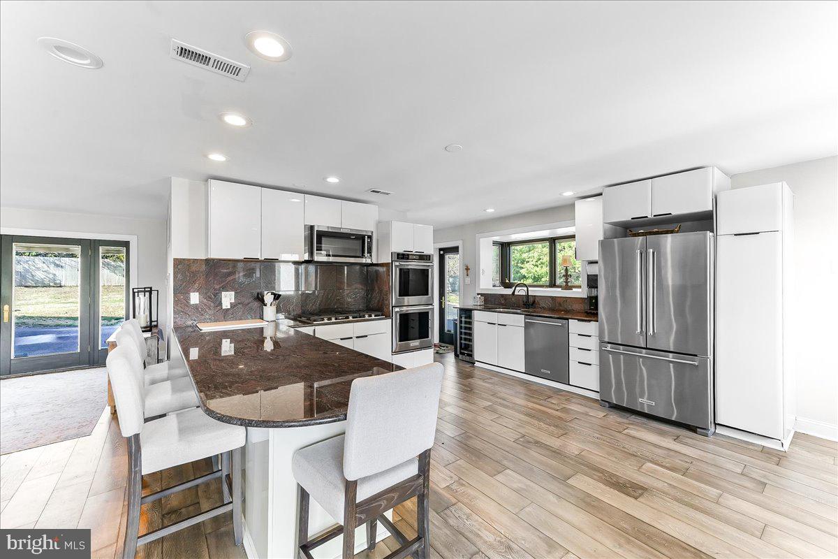 1056 Lenape Road West Chester, PA 19382 - Photo 13 of 48 a kitchen with refrigerator cabinets dining table and chairs