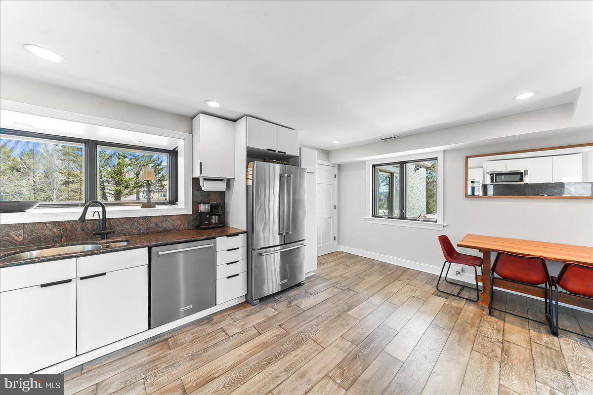 1056 Lenape Road West Chester, PA 19382 - Photo 16 of 48 a kitchen with stainless steel appliances granite countertop a refrigerator a sink dishwasher a dining table and chairs with wooden floor