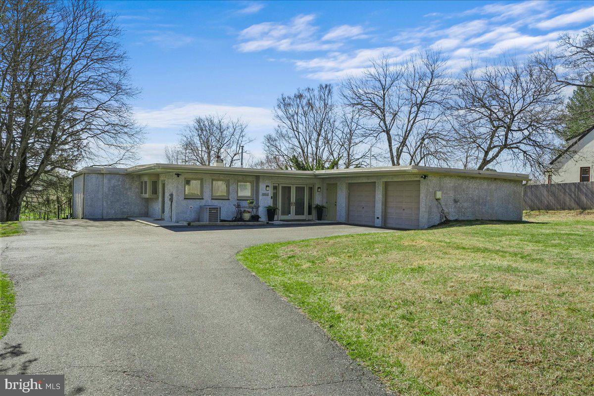 1056 Lenape Road West Chester, PA 19382 - Photo 2 of 48 a front view of house with yard and trees in the background