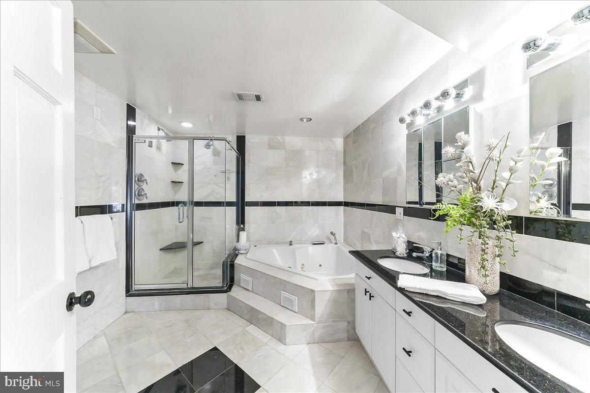 1056 Lenape Road West Chester, PA 19382 - Photo 23 of 48 a spacious bathroom with a double vanity sink a large mirror and a shower