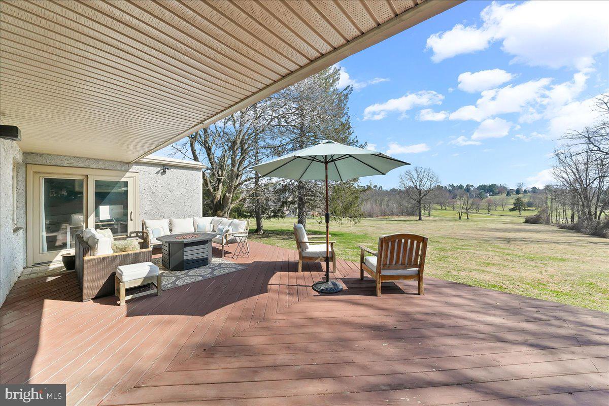 1056 Lenape Road West Chester, PA 19382 - Photo 32 of 48 a view of a patio with a dining table and chairs under an umbrella