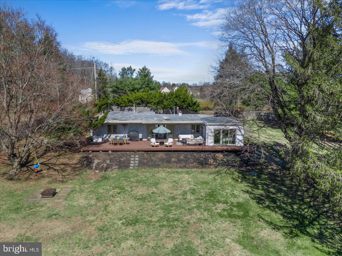 1056 Lenape Road West Chester, PA 19382 - Photo 41 of 48 a backyard of a house with table and chairs and wooden fence