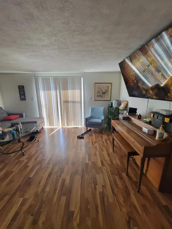 a living room with furniture a piano and wooden floor