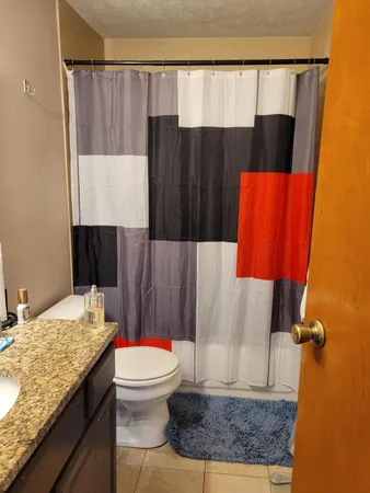a bathroom with a granite countertop sink toilet and shower
