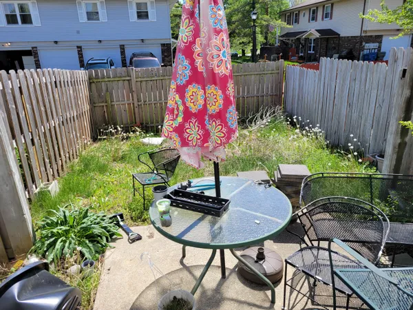 a backyard with table and chairs with a yard