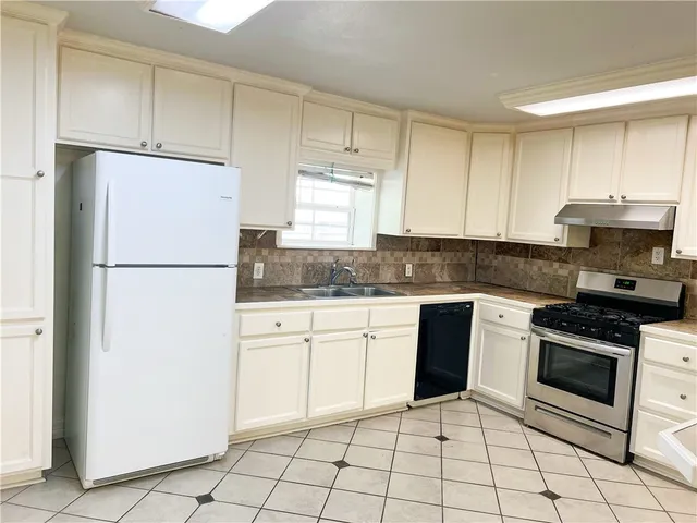 a kitchen with granite countertop white cabinets and white appliances
