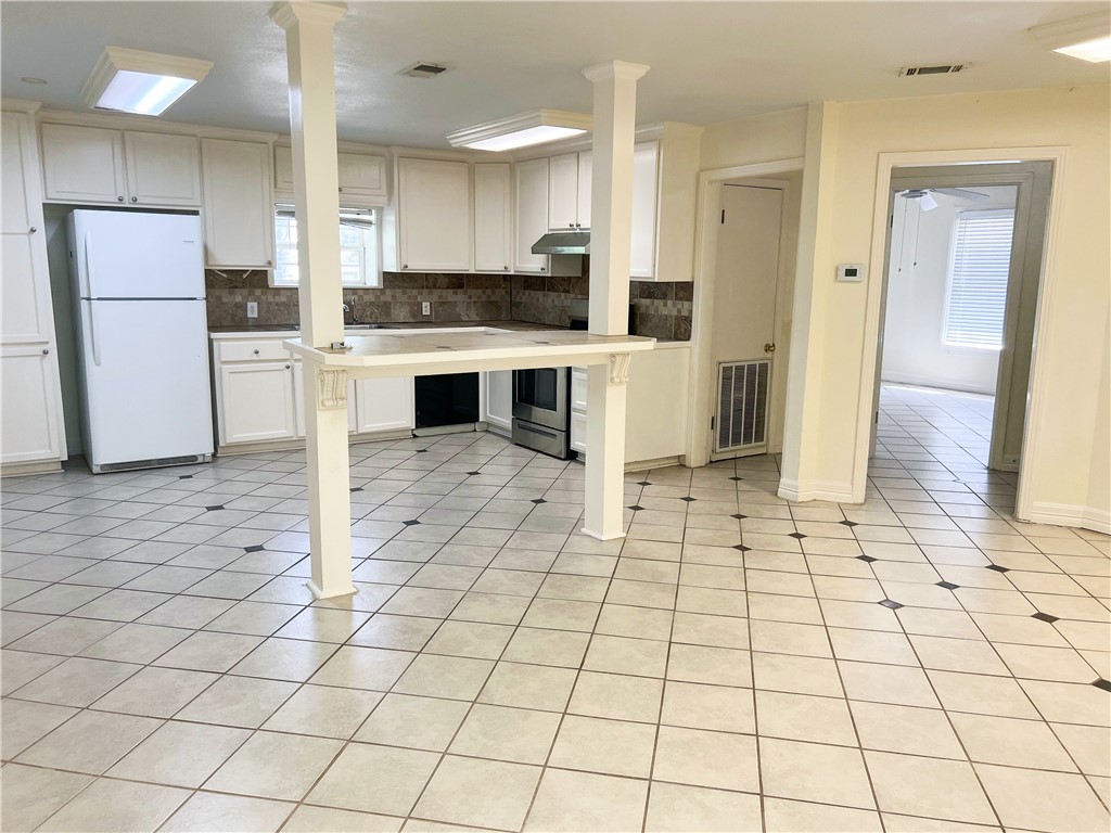 933 South Rife Street Aransas Pass, TX 78336 - Photo 13 of 17 a large white kitchen with a stove a refrigerator and a cabinets
