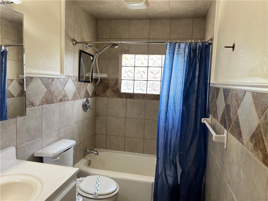 933 South Rife Street Aransas Pass, TX 78336 - Photo 4 of 17 a bathroom with a toilet and a bath tub