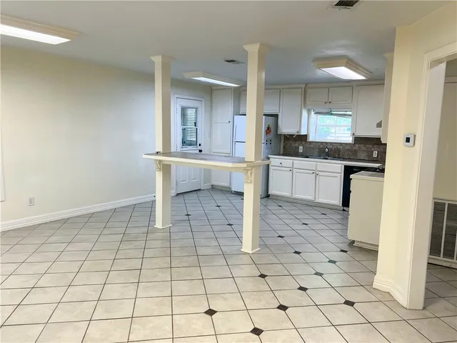 a room with washing machine and view of living room